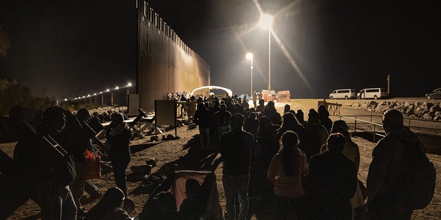 Immigrants wait to be processed by the U.S. Border Patrol after crossing the border from Mexico on December 30, 2022, in Yuma, Arizona.