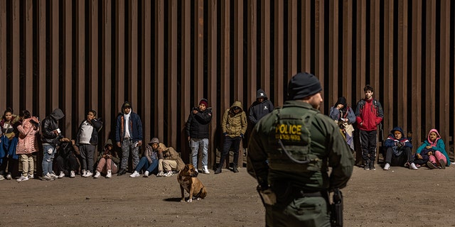 Immigrants wait to be processed by the U.S. Border Patrol after crossing the border from Mexico on December 30, 2022, in Yuma, Arizona.