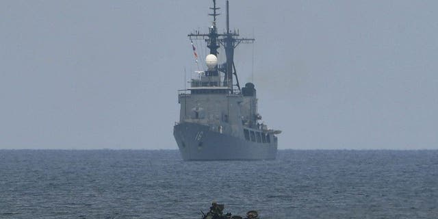 A US assault amphibious vehicle (AAV) manoeuvers past Philippine navy's frigate Ramon Alcaraz during a joint military exercisein the South China Sea